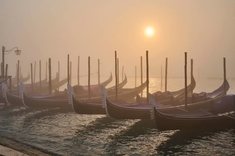 View from 'Colonna di San Marco e San Teodoro' on the gondolas lying in the water at sunrise in