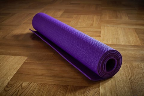Yoga mat on wooden floor