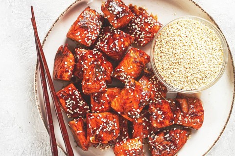 Fried pieces of salmon teriyaki with sesame seeds, top view