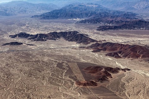 View from the air of a desert landscape with mountains and unusual line patterns, the geoglyphs and
