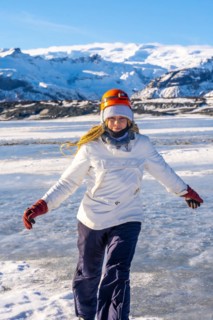 Woman smiling after emerging from a cave on the Vatnajokull glacier on vacation in Iceland