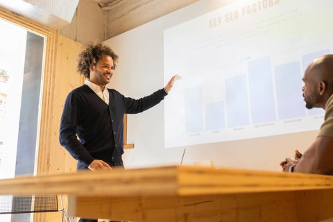 A professional giving a presentation in a modern coworking space in Barcelona. The setting features