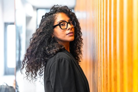 Beauty latin businesswoman turning to look at camera with confidence inside a financial modern