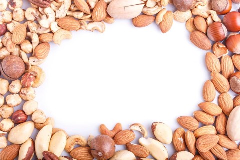 Frame made from different kinds of nuts on white background. hazelnut, brazil nut, almond, pumpkin