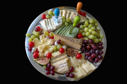 Cheese platter with different types of cheese and grapes on a black background, Bavaria, Germany