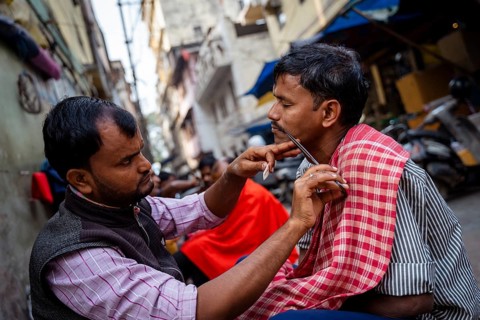 People shave in a street barber shop in Guwahati, India on 1 February 2025
