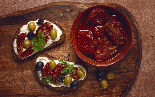 Sandwich with cream cheese, dried tomatoes, olives, breakfast, top view