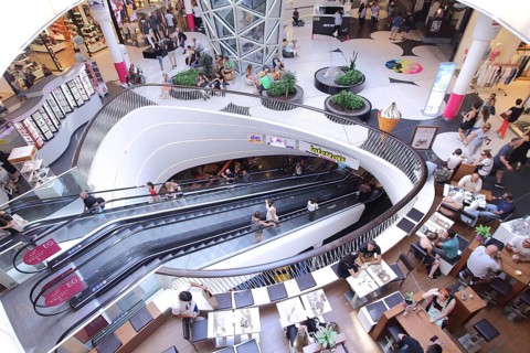 Modern shopping center with escalators and seating, pedestrian shopping, cafe, floor, bistro,