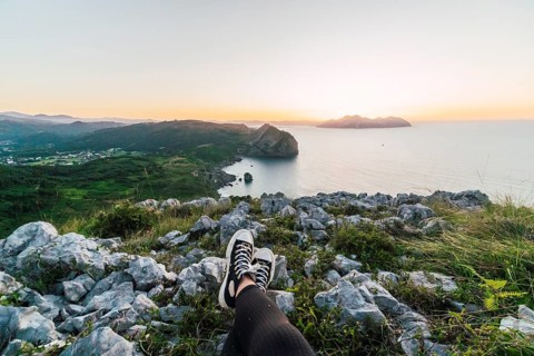 A breathtaking coastal sunrise with rocky foreground The gentle gradient of the sky meets the calm