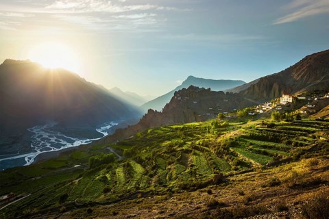 Dhankar gompa (monastery) on cliff and Dhankar village in Himalayas on sunset. Dhankar, Spiti