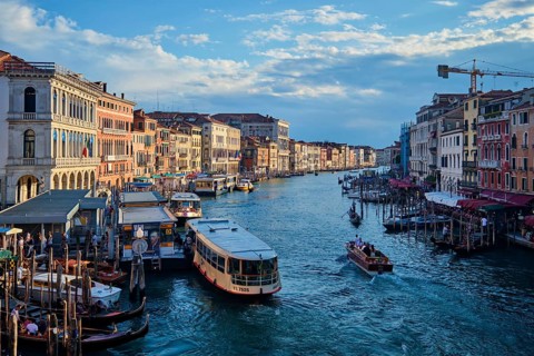 VENICE, ITALY, JUNE 27, 2018: Grand Canal with boats, vaporetto and gondolas on sunset from Rialto