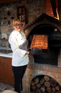 Greek woman showing a freshly baked Greek olive bread, Laconia, Peloponnese, Greece