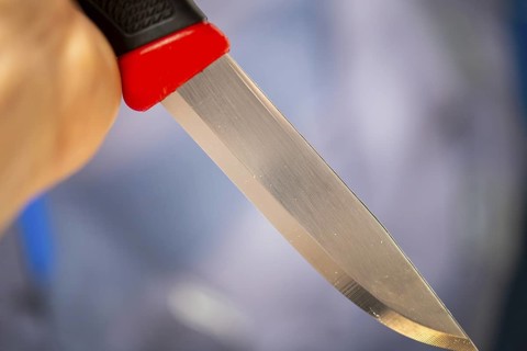 Symbolic image of a knife attack: close-up of a knife in a man's hand