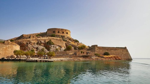 A fortress on the coast with a round tower, old stone walls and a view of the sea, Venetian sea
