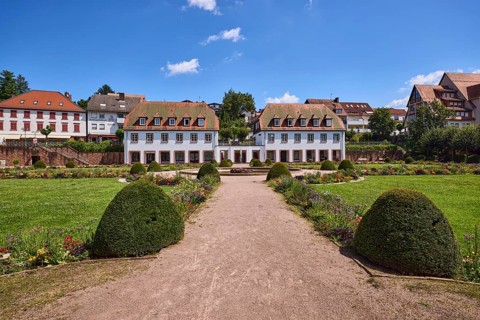 Pleasure garden, garden with lawn, path, sand, general buildings, blue sky with white clouds,