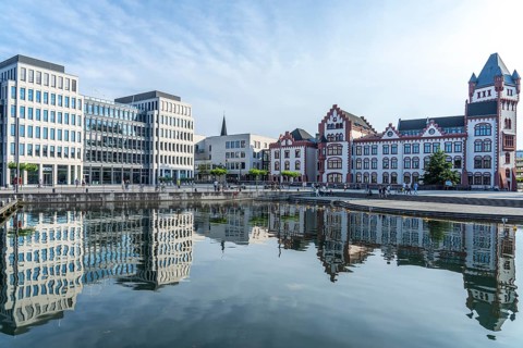 The Hörder Castle and modern office buildings on Lake Phoenix in Dortmund, North Rhine-Westphalia,