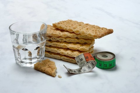 Crispbread and glass of water, measuring tape