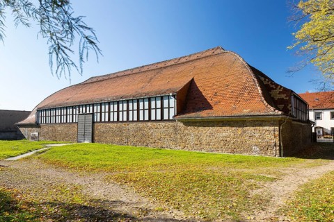 Renovated indoor riding arena at the old hunting lodge with striking column-free roof using the