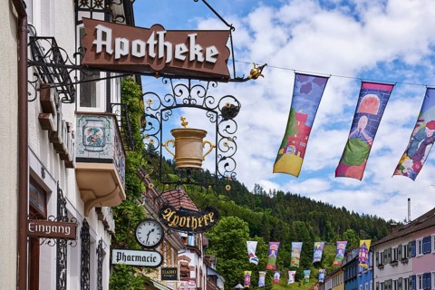 Historic pharmacy, nose sign, pharmacy, facade clock, historic building, old town, flags for the