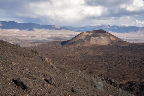 A slope with volcano and rocky terrain, surrounded by a mountain range, Argentina, volcanoes, lava