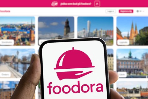 Foodora logo is displayed on smartphone. Foodora is an online food delivery brand owned by Delivery