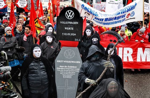 A symbolic VW coffin is carried by Volkswagen employees to the collective bargaining negotiations