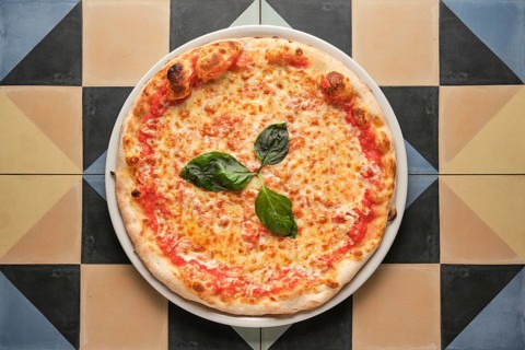 Overhead shot of a classic pizza margherita, featuring melted mozzarella, tomato sauce, and fresh