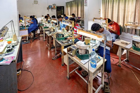 A busy workshop where people work on making jewelry, surrounded by tools, the sapphire and gemstone
