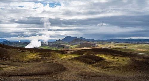 Volcanic landscape with colourful hills, steam of the Krafla geothermal power plant, geothermal