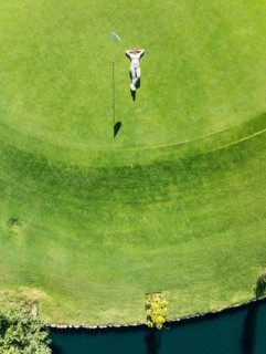 Woman lying on the green at the La Noria Golf Resort. Aerial view. Drone shot. Málaga province,