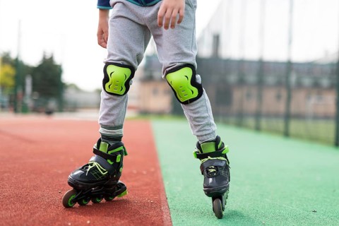 The legs of the little boy roller skating