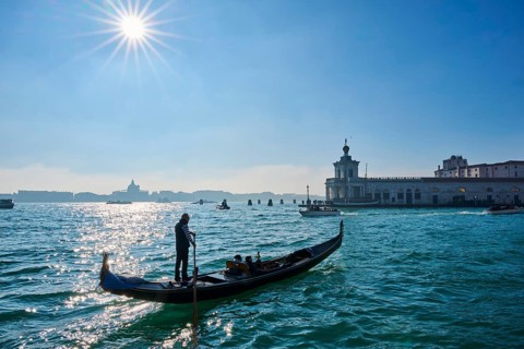 Wild carnival hustle and bustle on the 'Canal Grande' with decorated boats and masked people in