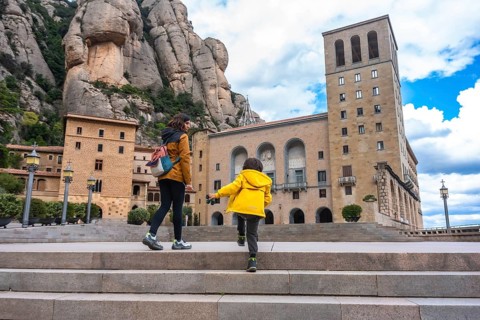Mother and son walking up stairs at santa maria de montserrat abbey, a benedictine monastery