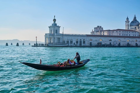 View from a gondola on 'Basilica the Santa Maria della Salute' with a gondola in front in Canal