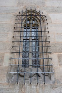 Pointed arch window with iron grating with a dog sculpture, late Gothic hall church of St George,