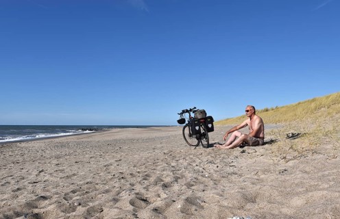 Senior takes a break by bike on the beach in Denmark