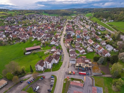 Village view with a central street surrounded by houses and green land, Ostelsheim, district of