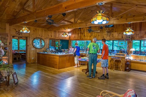 Customers shop and observe a glass blowing demonstration at Butts On The Creek restaurant and gift