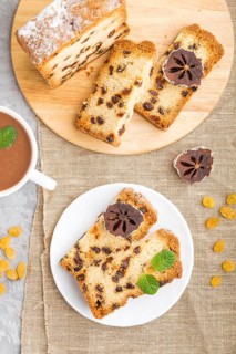 Homemade cake with raisins, dried persimmon and a cup of hot chocolate on a gray concrete