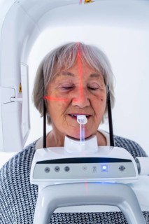 Senior woman undergoing a dental x ray scan with advanced equipment in a modern dental clinic,