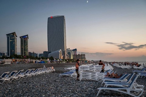 BATUMI, GEORGIA - AUGUST 22, 2023: Workers folding deckchair