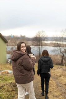 Three female friends enjoy a leisurely walk outdoors, engaging in warm conversation. One woman is