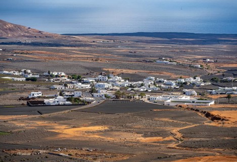 Town with white houses in dry volcanic landscape with fields, Lanzarote, Canary Islands, Spain
