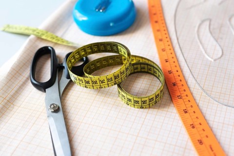 A vibrant collection of sewing essentials including scissors, measuring tape, and a ruler, all