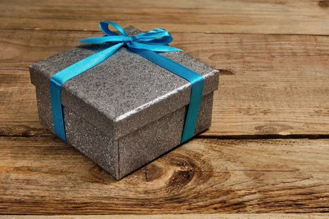 Gift birthday Christmas present concept, silver gift box with blue ribbon on old wooden background