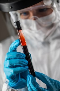 Female Lab Worker Holds Test Tube of Blood For Testing