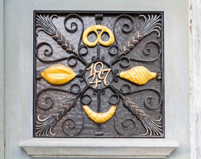 Various signs for a metal bakery as door decoration, old town centre of Cadolzburg, Bavaria,