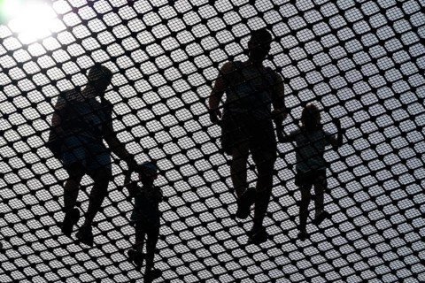 Visitors balance against the light on a steel net on the observation tower on the Usedom treetop