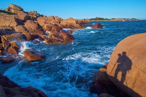 Large rocks on the Granit Rose coast, with the silhouette of a photographer, Ploumanach, Cote De