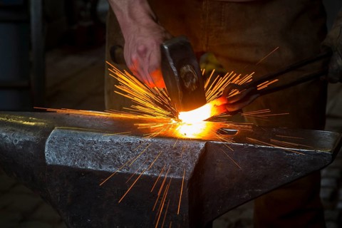 Sparks spray, a blacksmith forging, working at the Ehnert forge in Dresden-Bühlau, Saxony, Germany